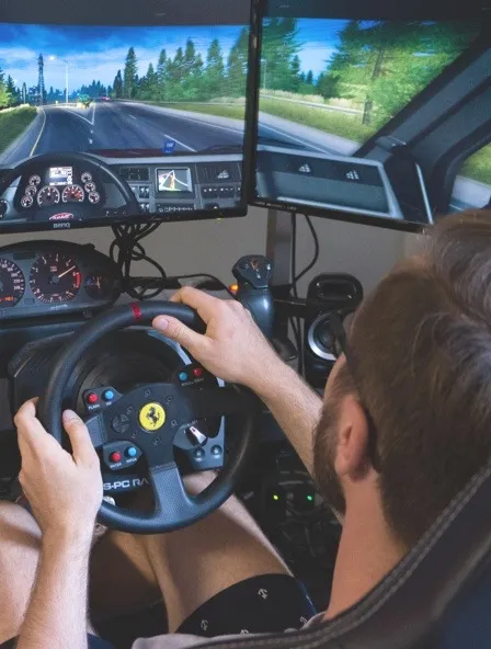 A man sitting in a car racing simulator.